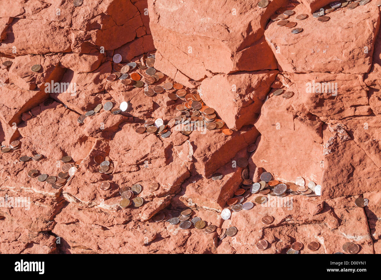 Pièces de monnaie jetées sur une colline de roche rouge à la chapelle de la Sainte Croix à Sedona, Arizona. Banque D'Images
