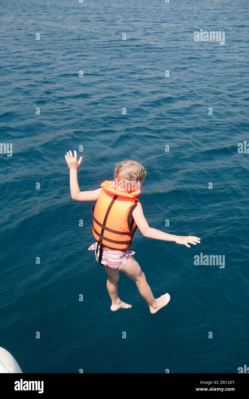 Petite fille en veste de sauter à l'eau de mer Banque D'Images