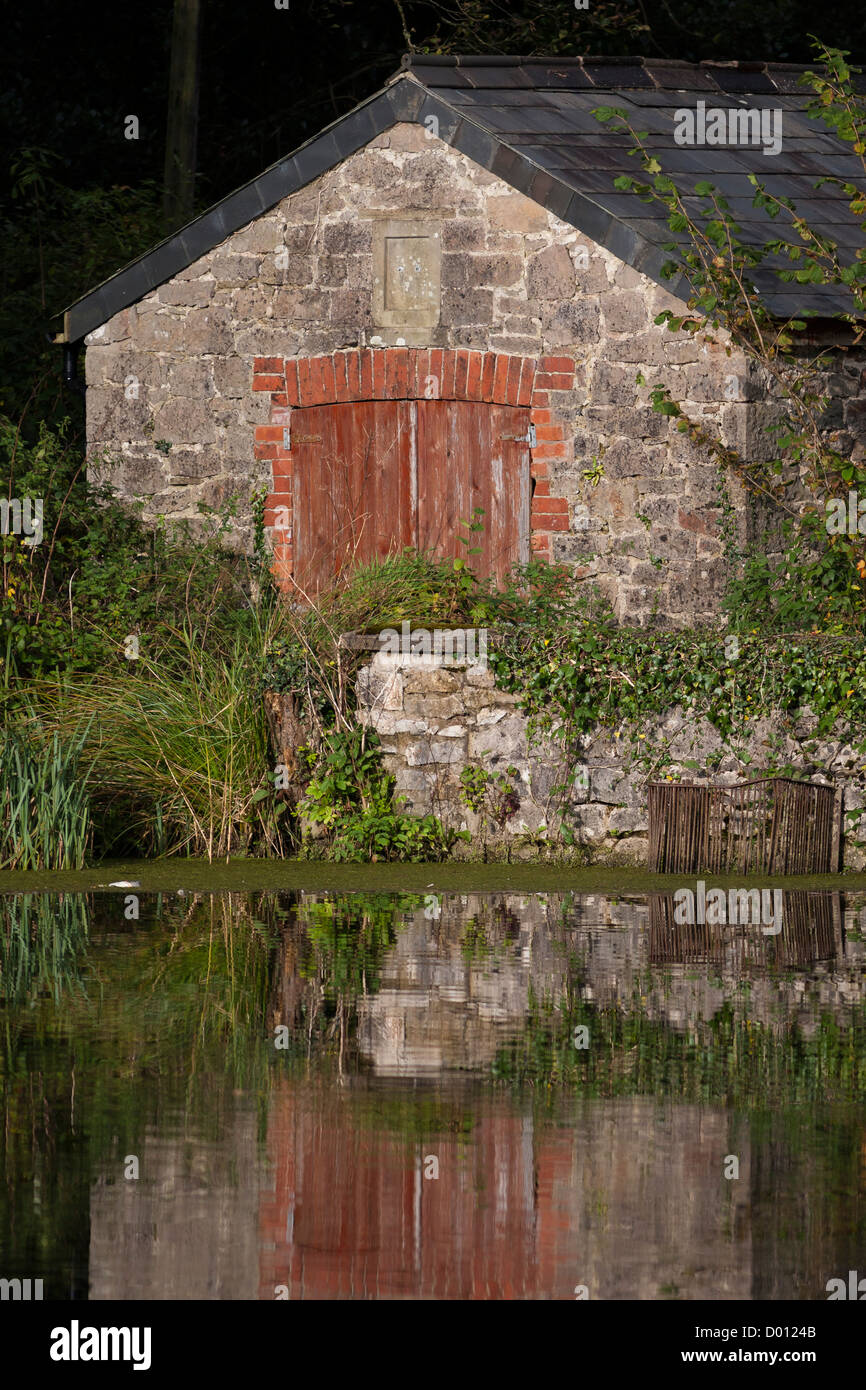Bateau maison au bord du lac dans la végétation Banque D'Images