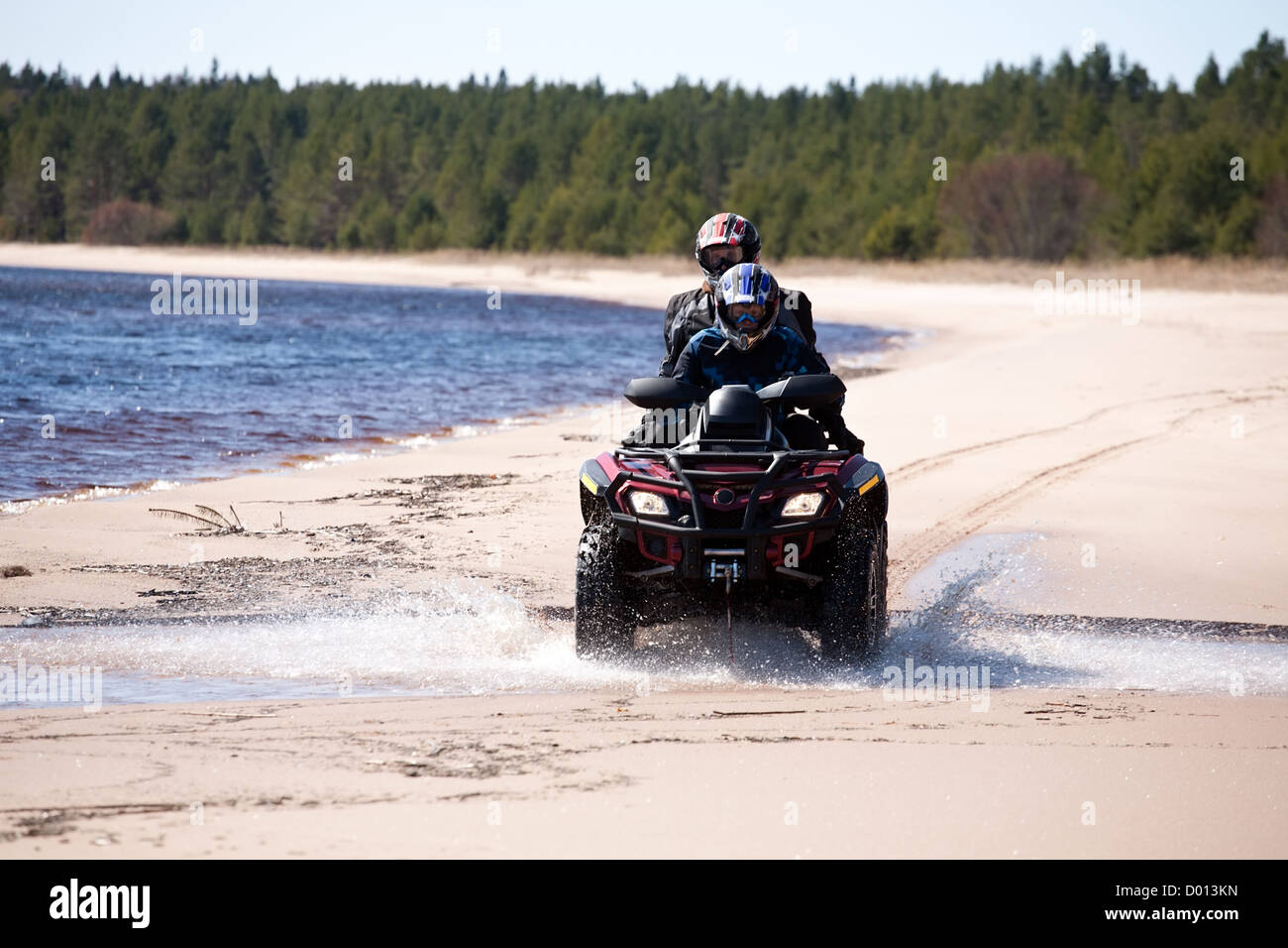 Deux hommes à cheval petit véhicule tout-terrain sur la côte de sable de lake forest, front view Banque D'Images