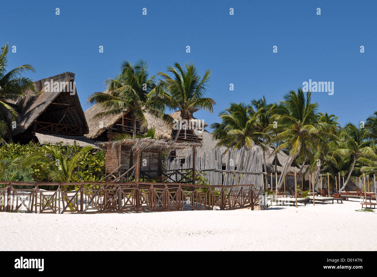 Resort sur la plage avec des palmiers et des huttes Banque D'Images
