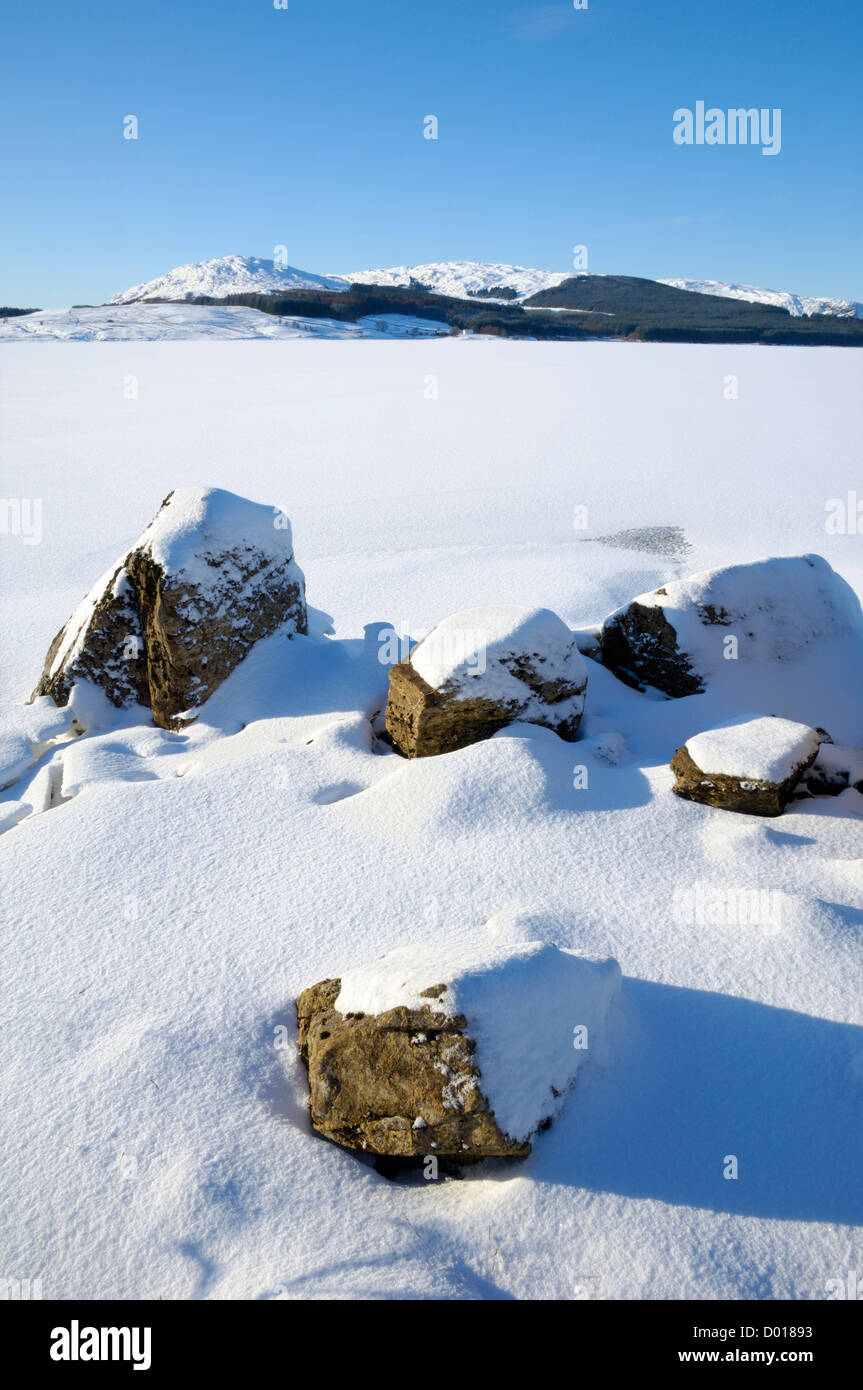Clatteringshaws Loch, gelé et recouvert de neige de l'hiver, Dumfries et Galloway, Écosse Banque D'Images
