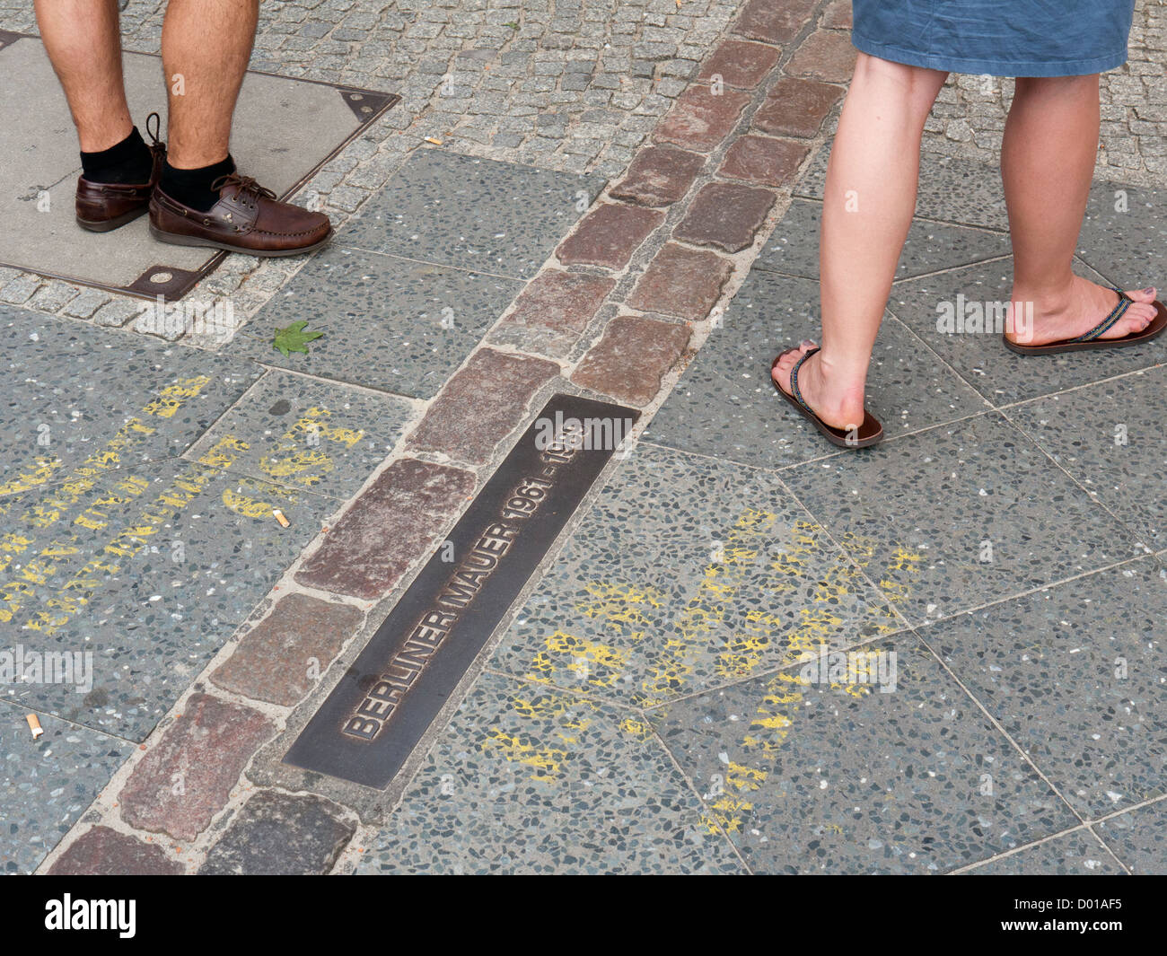 Deux personnes debout de chaque côté de l'emplacement de l'ancien mur de Berlin se tenait à Berlin Allemagne Banque D'Images