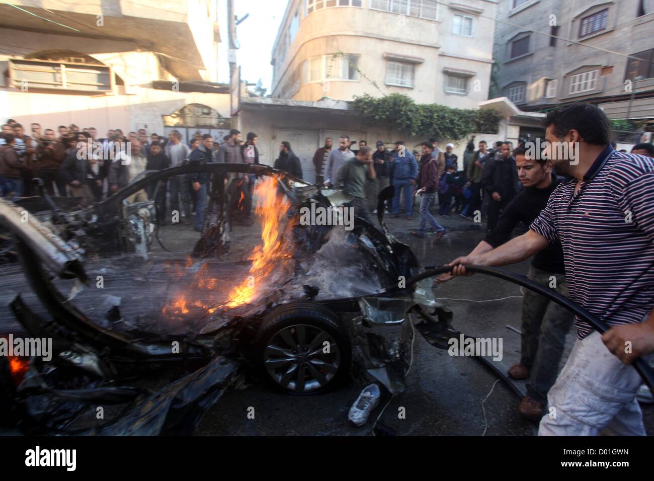 14 novembre 2012 - La ville de Gaza, bande de Gaza, territoire palestinien - pompiers palestiniens éteindre l'incendie de la voiture d'Ahmad Jaabari, chef de la branche militaire du Hamas, les Brigades Ezzedin Qassam, après qu'il a été touché par une frappe aérienne israélienne à Gaza le 14 novembre 2012. Le haut commandant du Hamas Ahmed al-Jaabari a été tué dans une frappe aérienne israélienne , medecins et une source du Hamas dit (crédit Image : © Ashraf Amra/APA Images/ZUMAPRESS.com) Banque D'Images