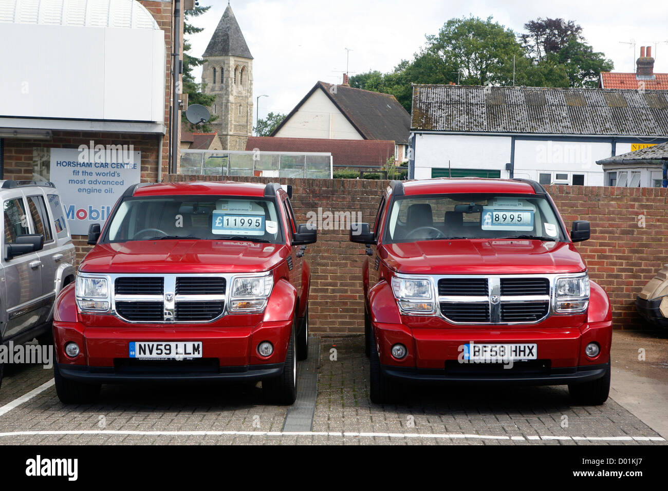 Deux grandes voitures garées à côté de l'autre dans un parking. Banque D'Images