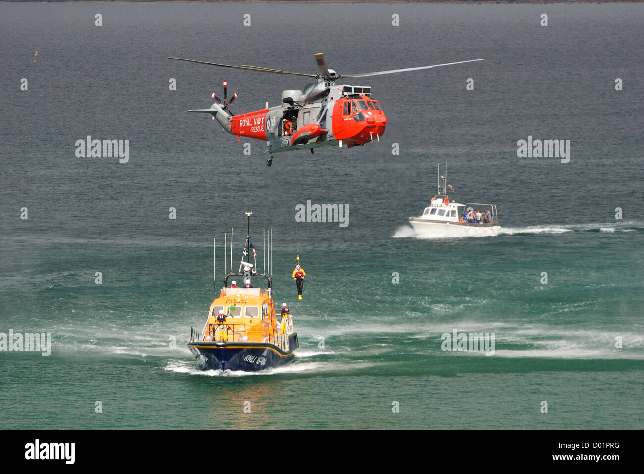 Un bonhomme de mer étant descendu sur un canot de sauvetage à partir d'un hélicoptère de recherche et sauvetage au large de Newquay, Cornwall, S W Angleterre, au cours d'un exercice de sauvetage en mer. Banque D'Images