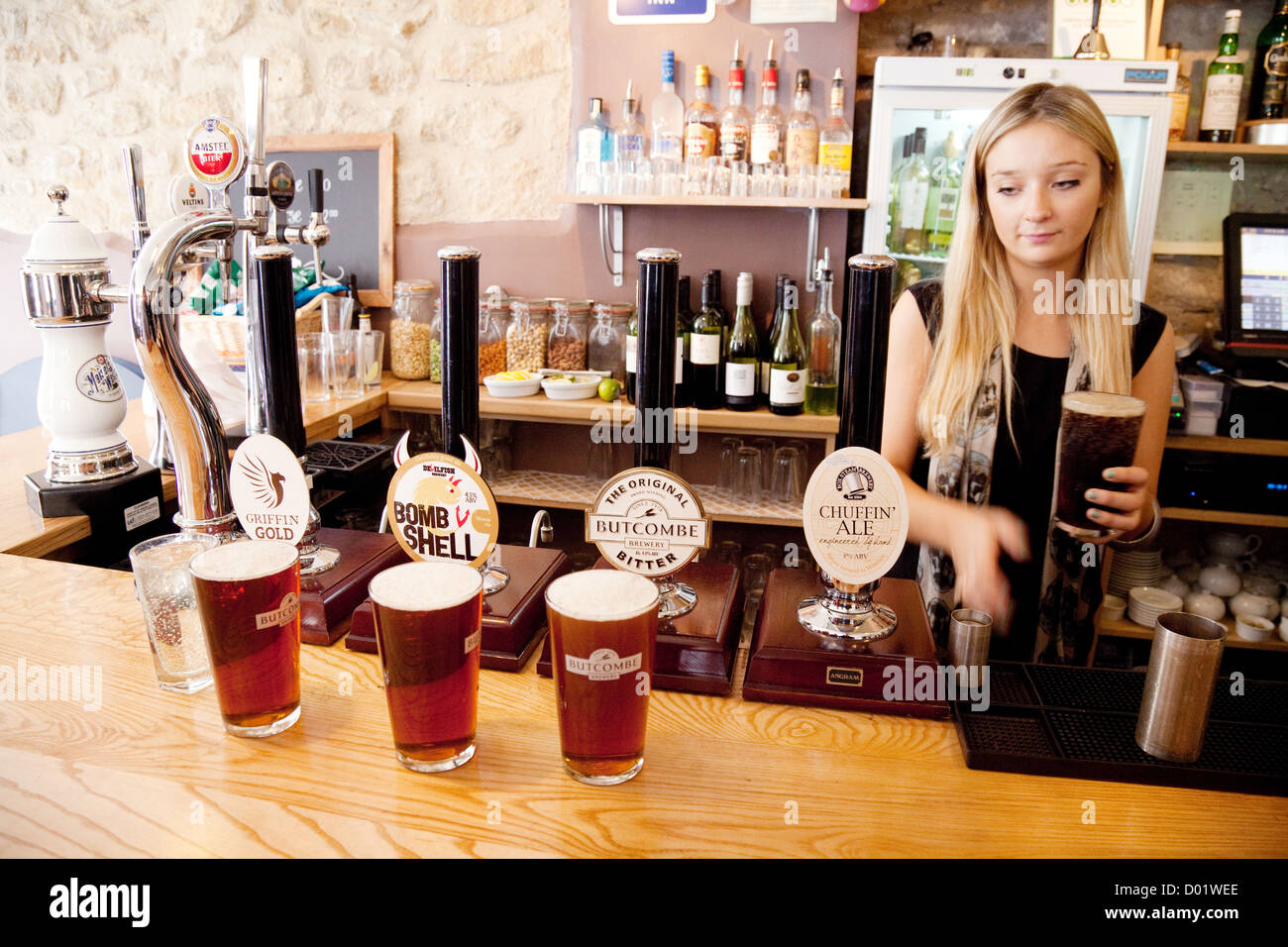 Une blonde barmaid servant des pintes de bière dans le Griffin Inn Somerset Bath, Royaume-Uni Banque D'Images