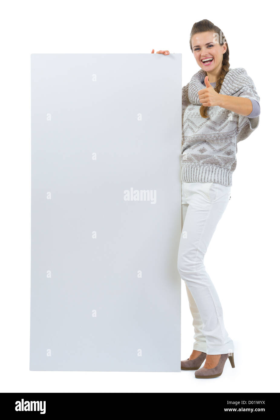 Happy woman in sweater holding blank billboard et showing Thumbs up Banque D'Images