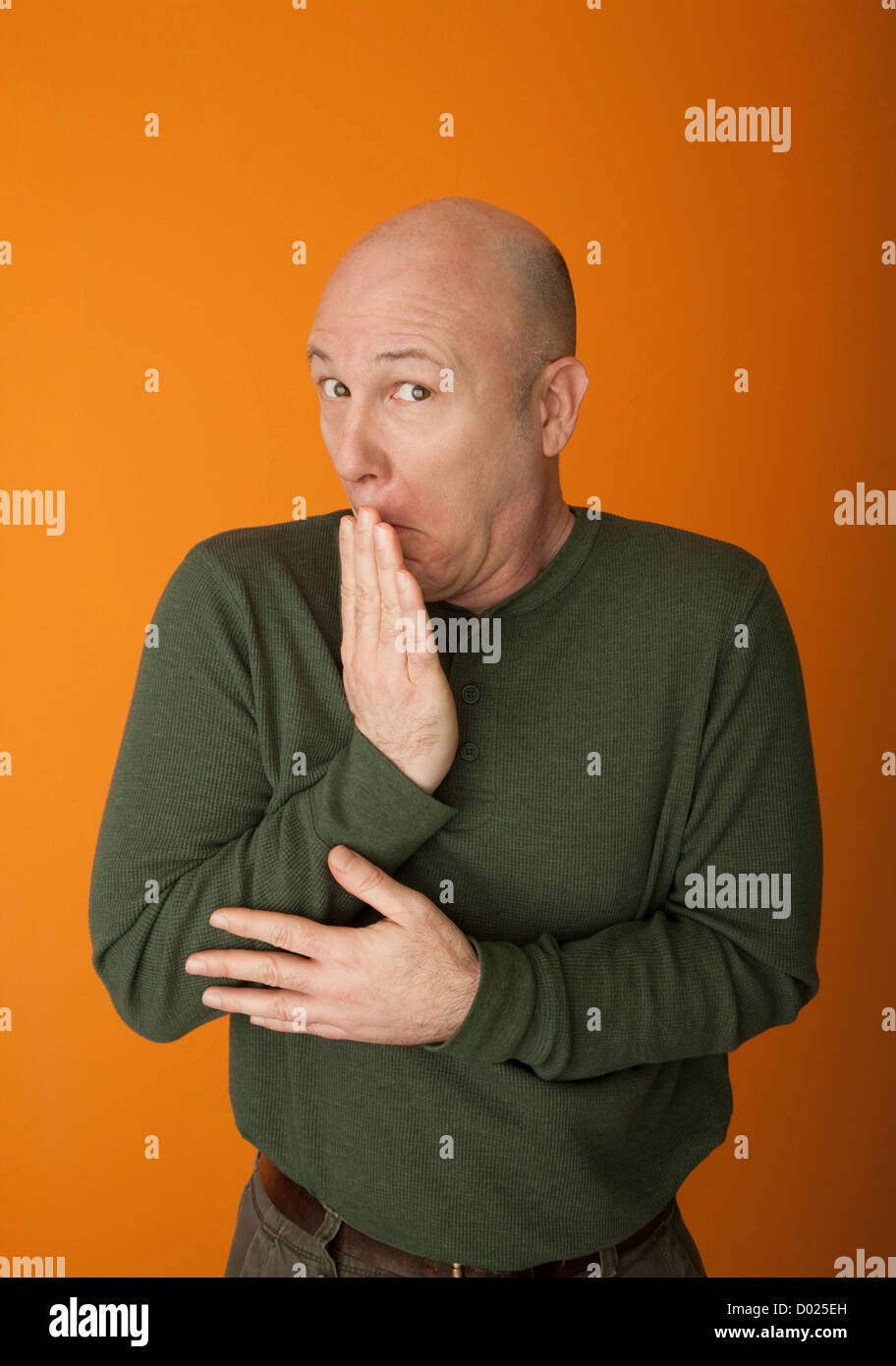 Choqué bald man avec la main sur la bouche Banque D'Images