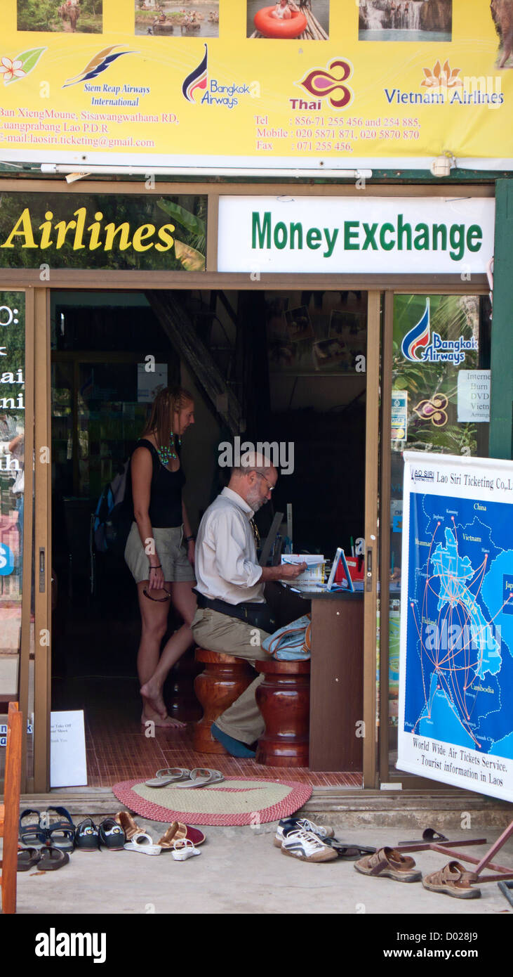 Les visiteurs de l'agent de voyages l'échange d'argent vieux quartier Luang Prabang au Laos Banque D'Images