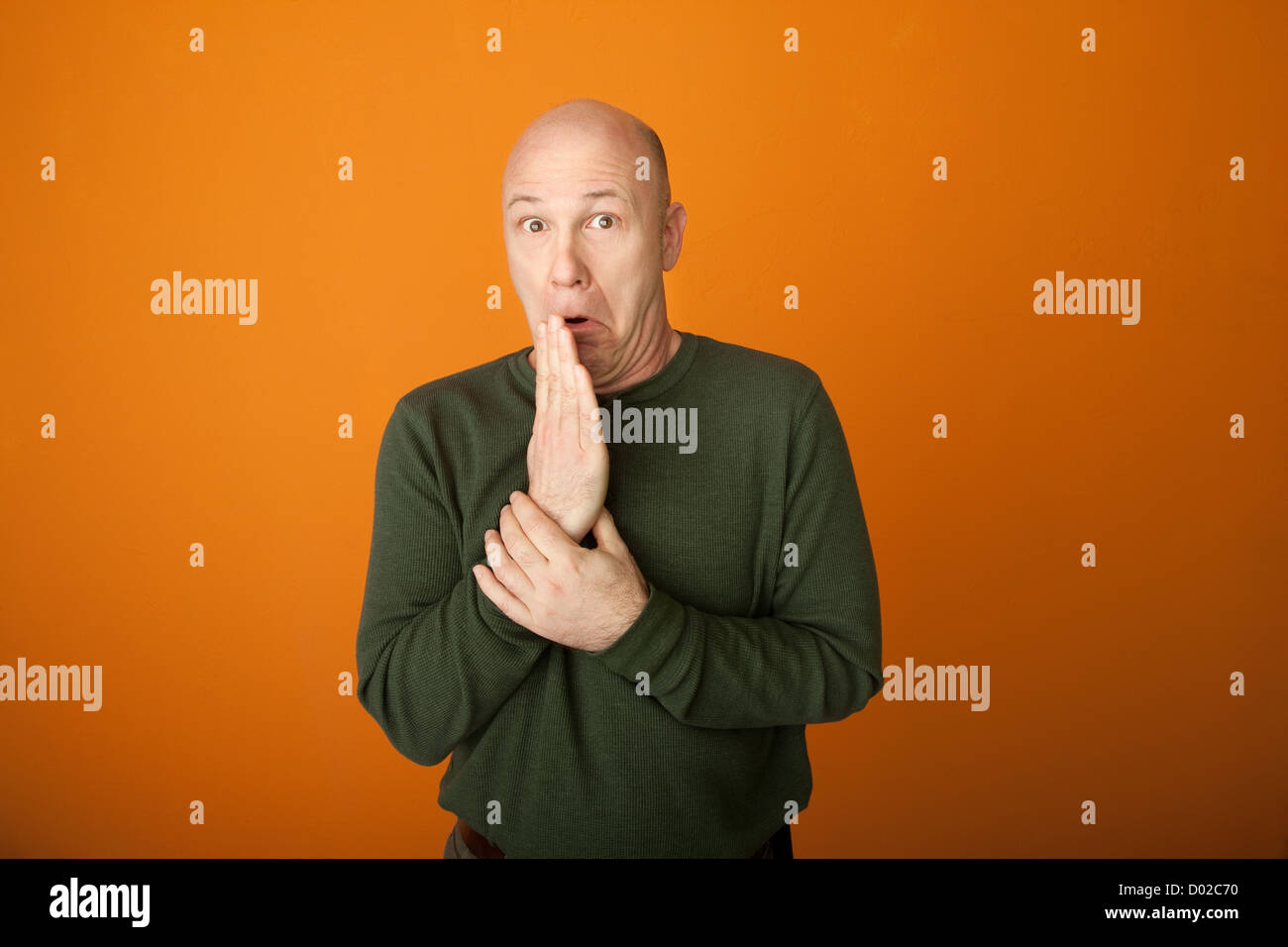 Choqué middle-aged man sur fond orange Banque D'Images