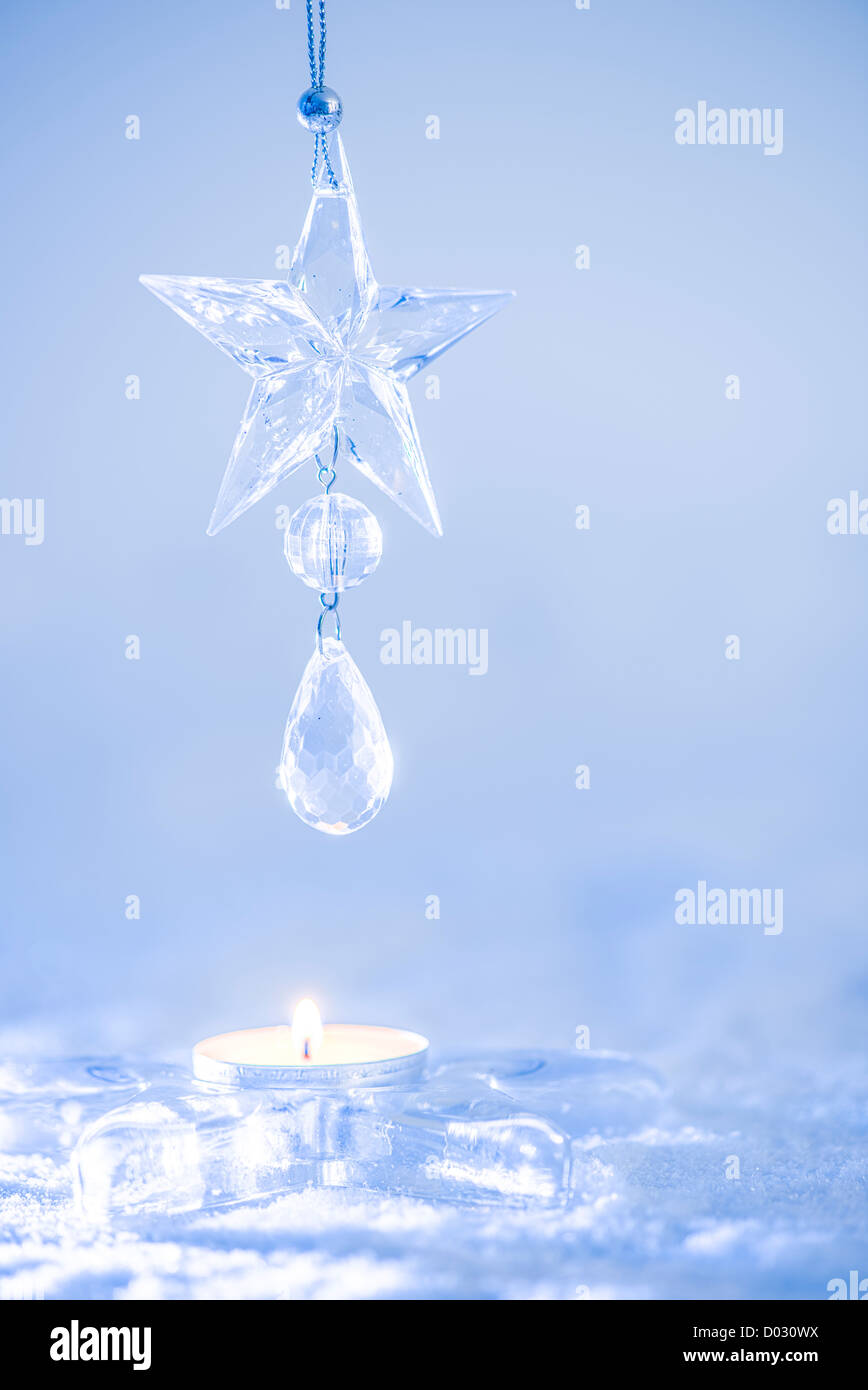 L'étoile de Noël en cristal. La décoration dans des chandelles sur la neige. Banque D'Images