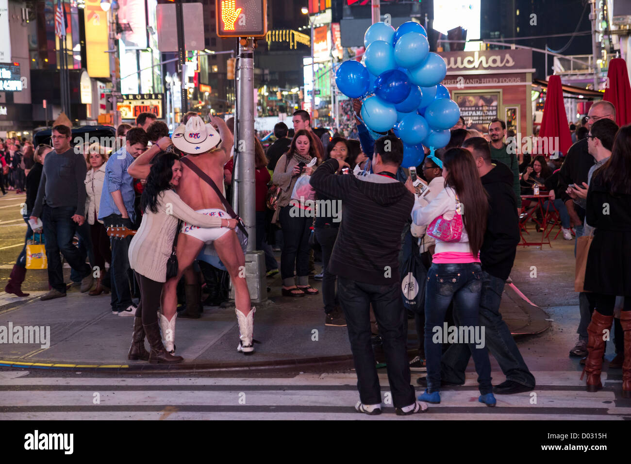 Les touristes photographiant le Naked Cowboy dans Time Square by night, New York Banque D'Images