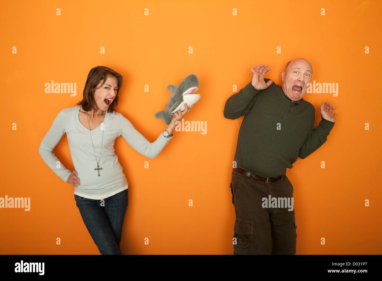 Belle femme de race blanche d'effrayer l'homme avec un jouet fourrure Banque D'Images