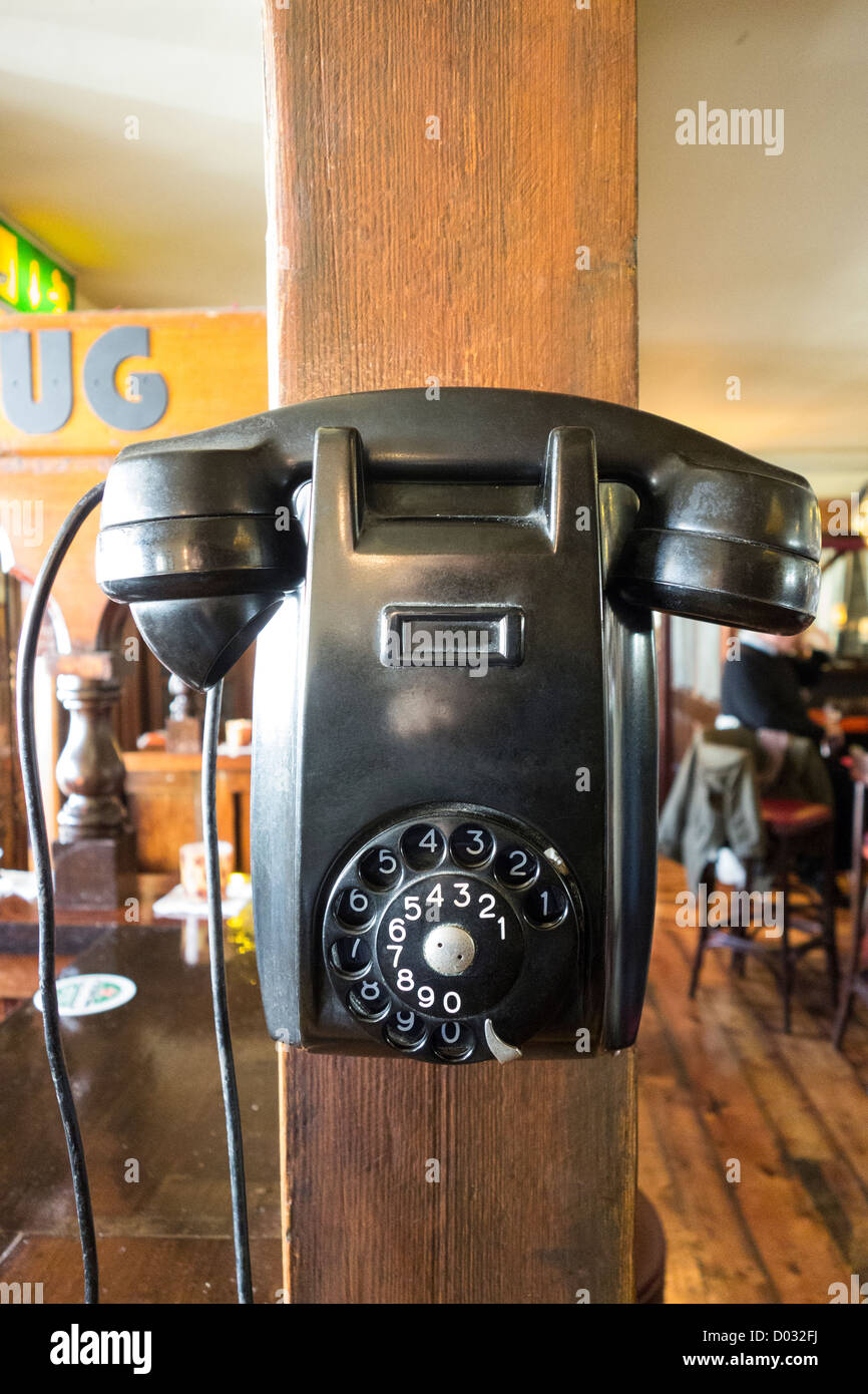 Un très vieux téléphone à cadran monté comme un décor sur le mur d'un pub irlandais Banque D'Images