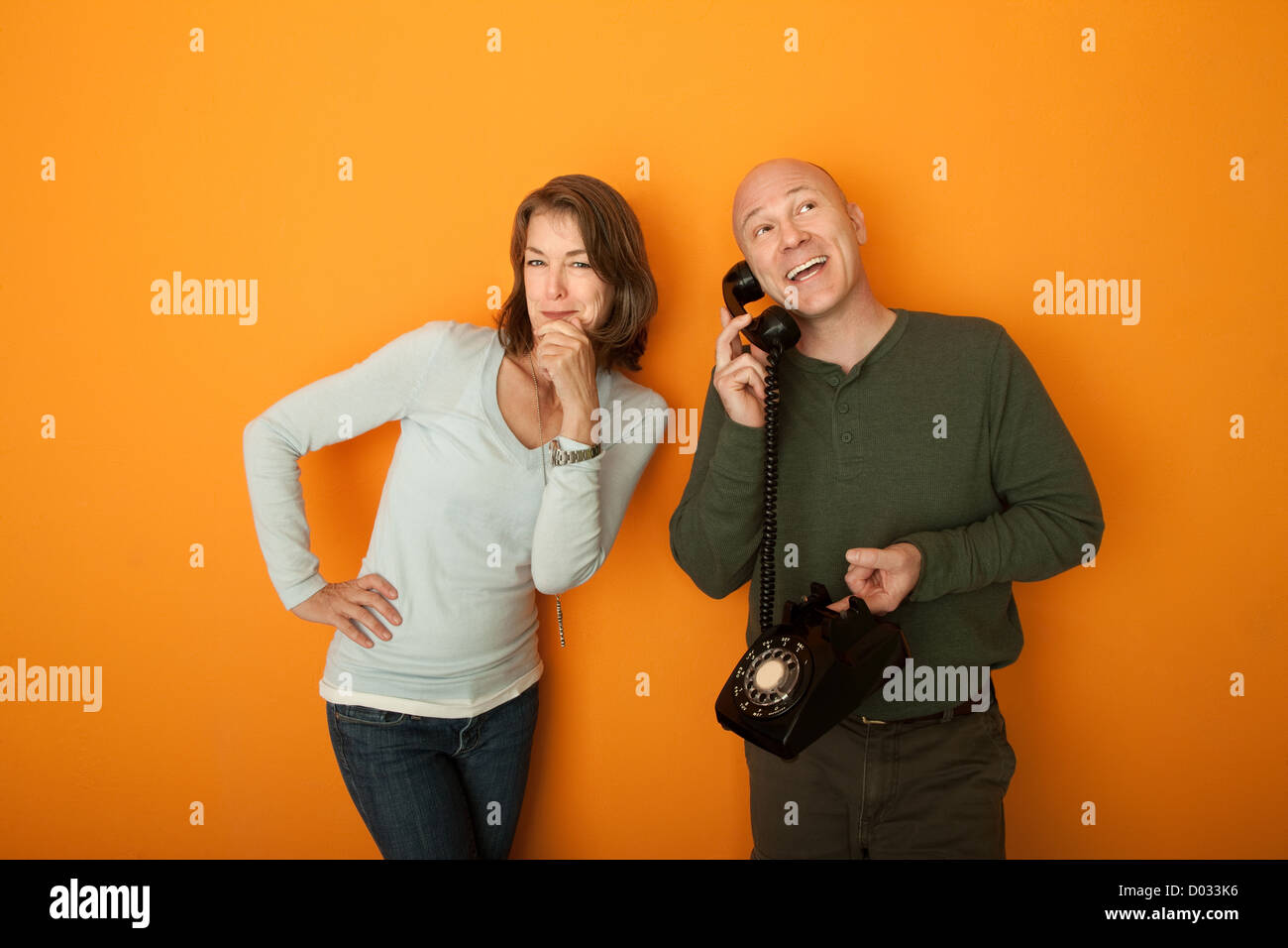 Middle aged man on téléphone tout en femme à l'écoute de la conversation Banque D'Images