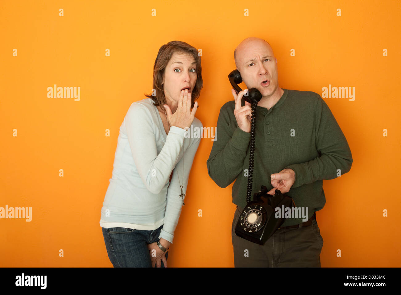 Choqué Caucasian woman with hand on bouche l'écoute d'une conversation téléphonique Banque D'Images