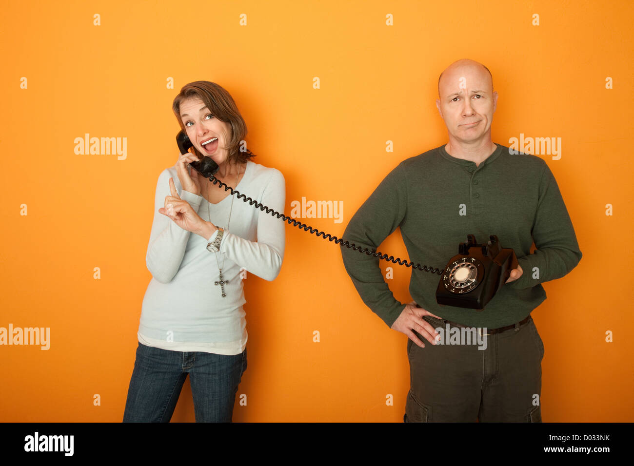 Happy Caucasian Woman on conversation téléphonique avec bored man Banque D'Images