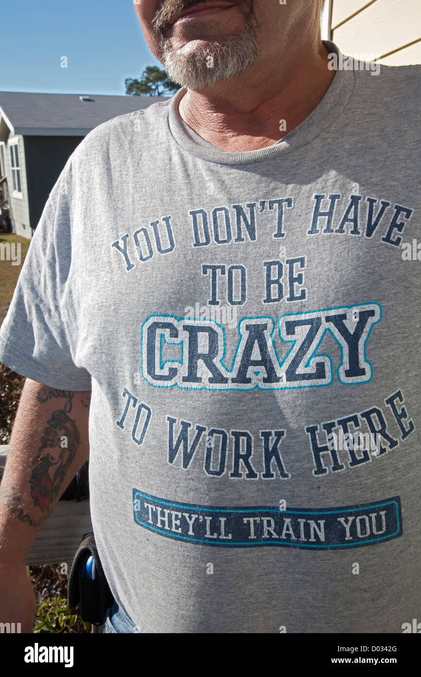 Bayou La Batre, Alabama - modèles d'un homme un t-shirt avec un commentaire sur son lieu de travail. Banque D'Images
