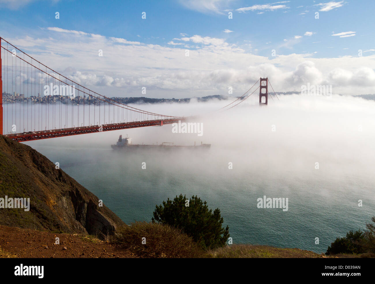 Un porte-conteneurs passe sous le Golden Gate Bridge à San Francisco, Californie enveloppé par le brouillard. Banque D'Images