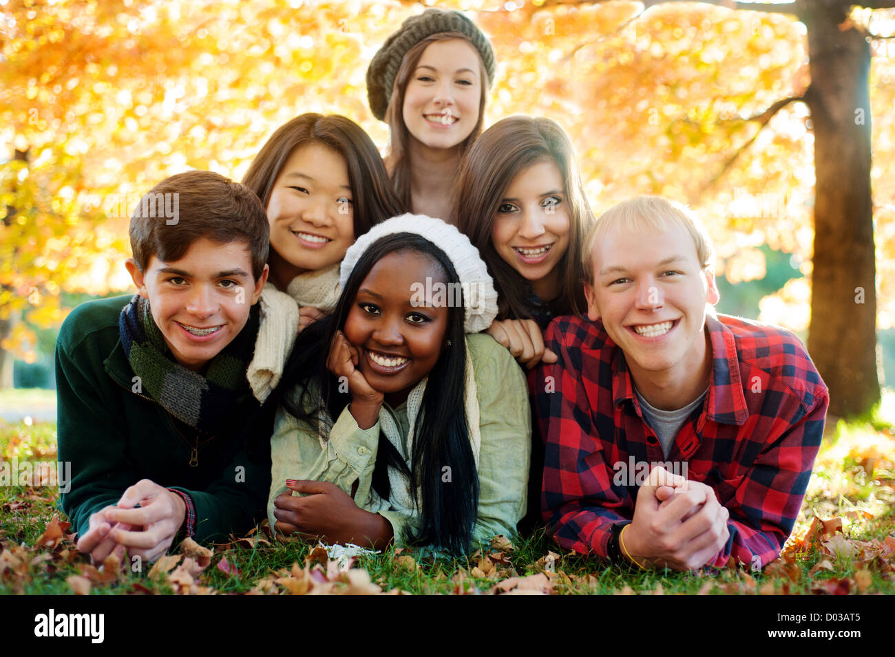 Groupe diversifié de smiling friends dans une pyramide en automne Banque D'Images