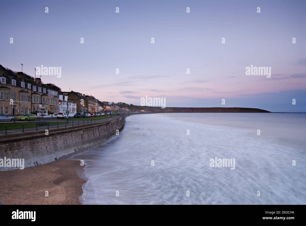 Filey Bay et le front de la recherche de la promenade comme la nuit tombe. Banque D'Images