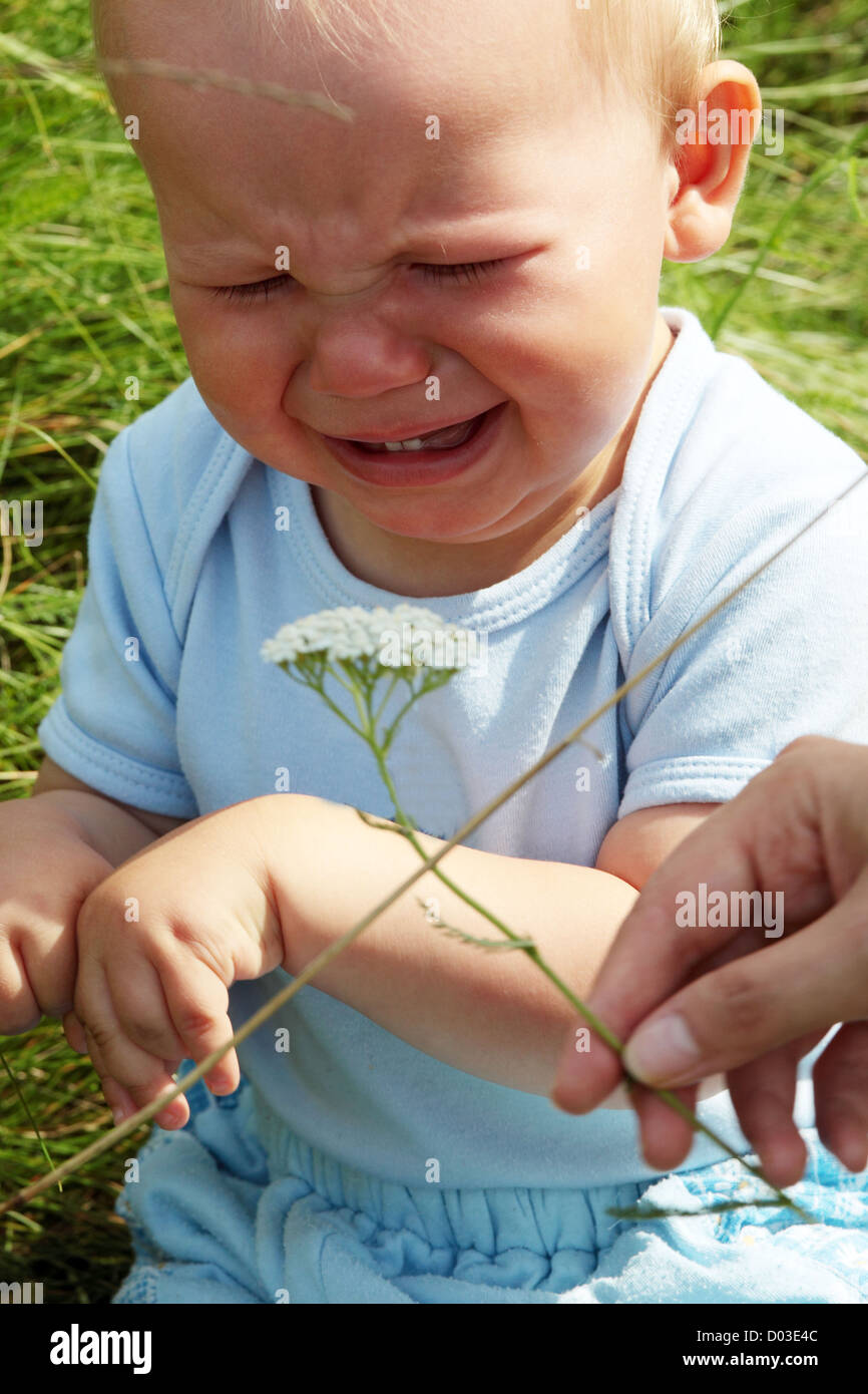 Crying baby boy en plein air au jour d'été ensoleillé Banque D'Images