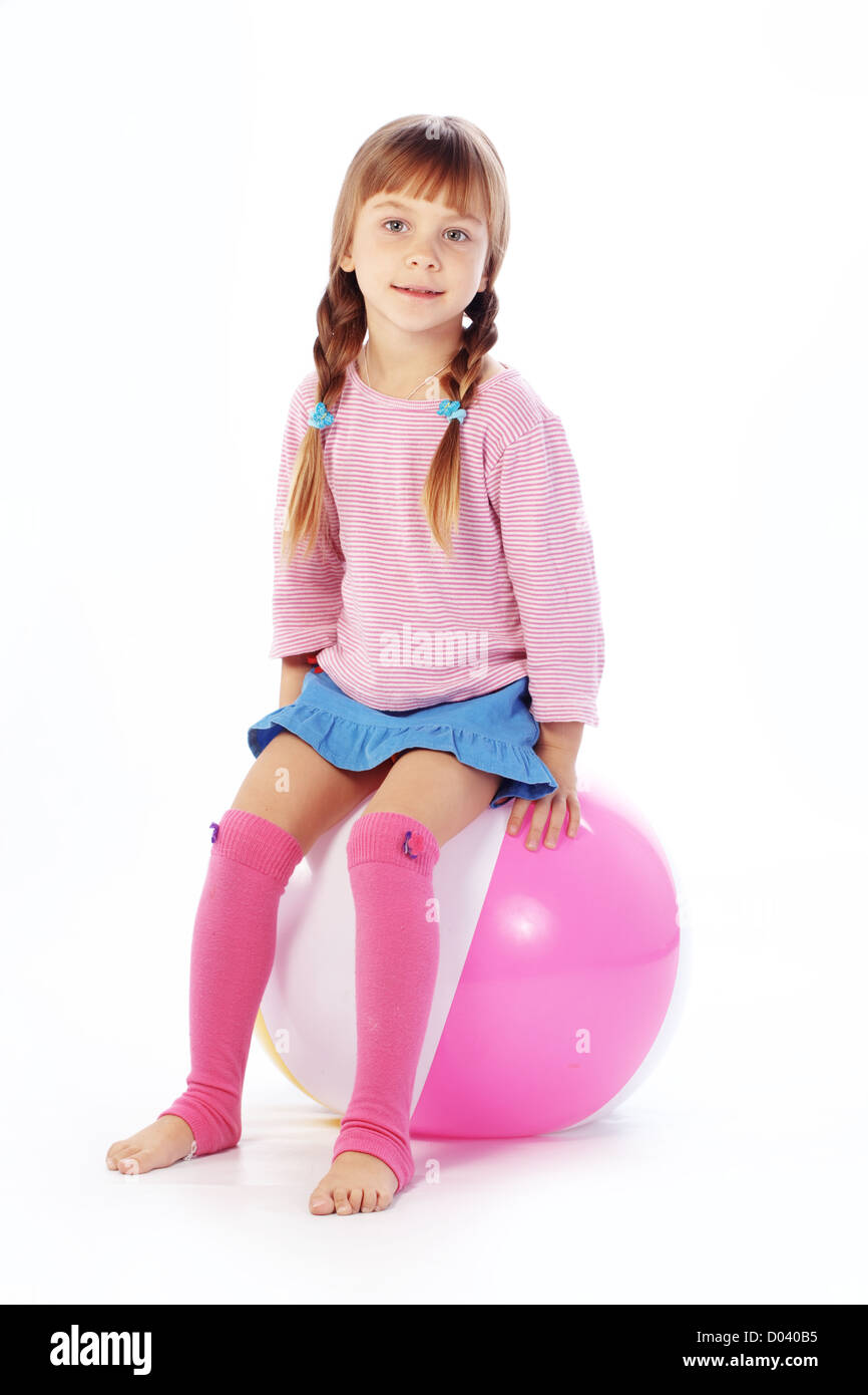 Enfant avec boule colorée sur fond studio blanc Banque D'Images