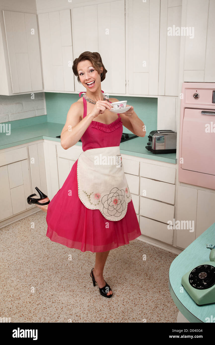 Middle-aged woman debout sur un pied dans la cuisine Banque D'Images