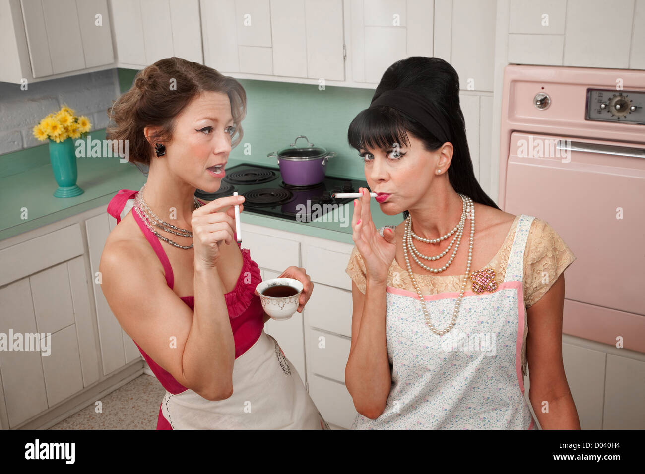Deux de style rétro d'âge moyen des femmes qui fument la cigarette et le café Banque D'Images