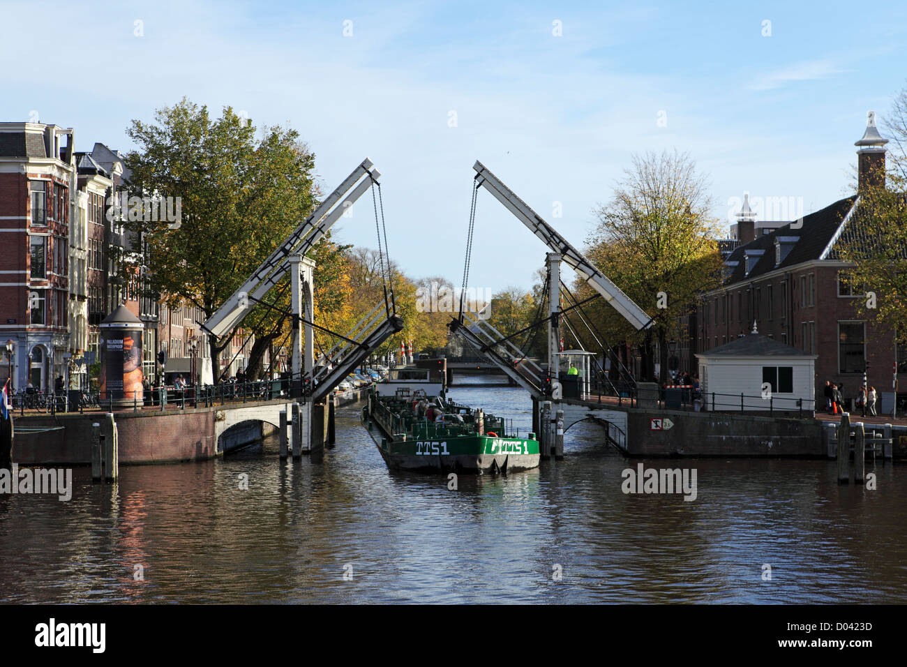 Une péniche passe par un pont ouvert au centre d'Amsterdam. Banque D'Images