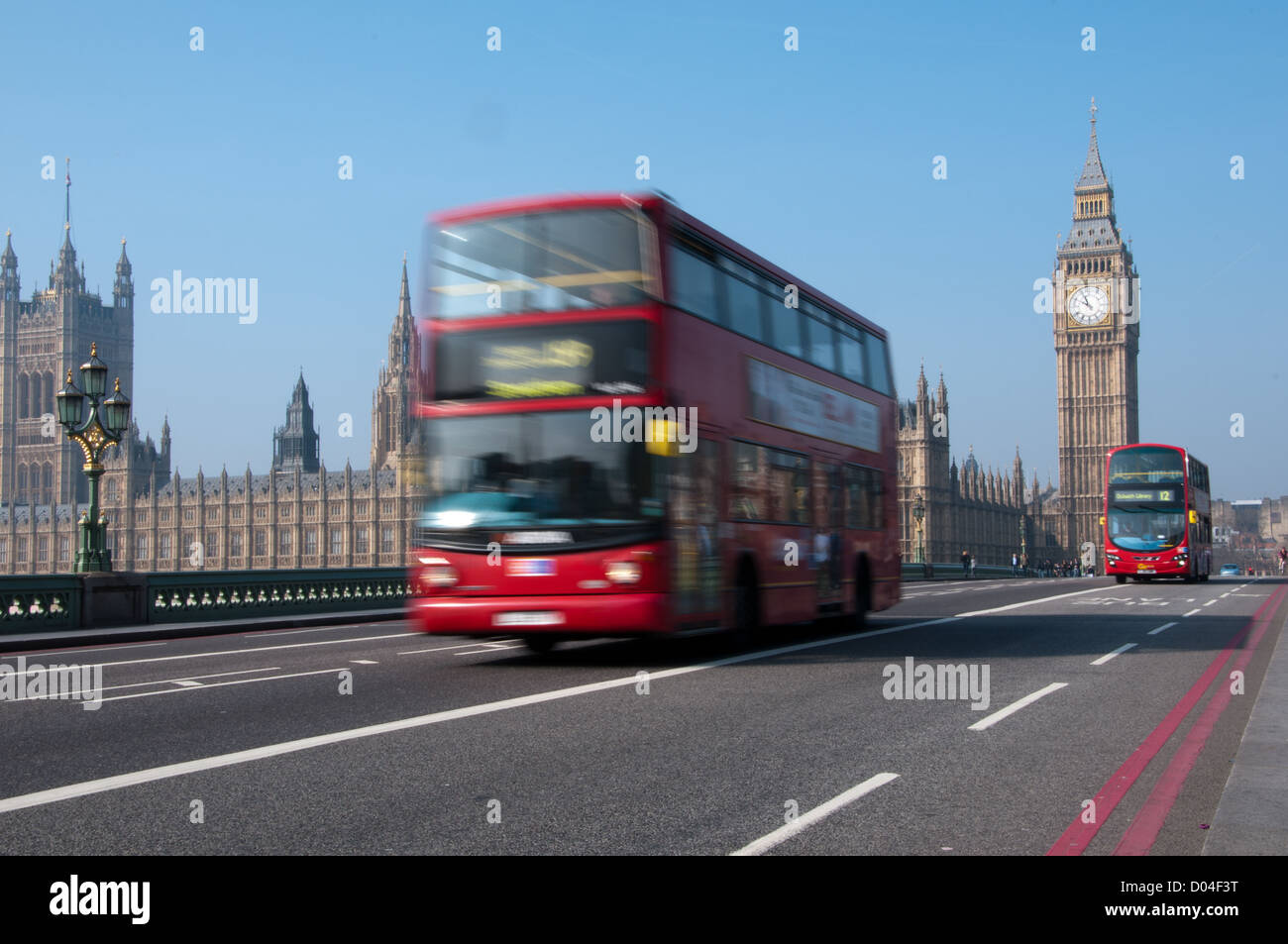 Red London bus se déplaçant dans Westminster Bridge. Bus a motion blur à ajouter à la circulation, les Maisons du Parlement dans l'image Banque D'Images