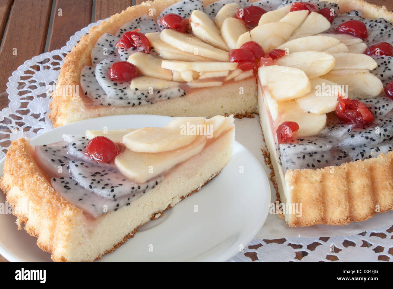 Gâteau de fruit avec la garniture de pommes et de cerises fruit du dragon Banque D'Images