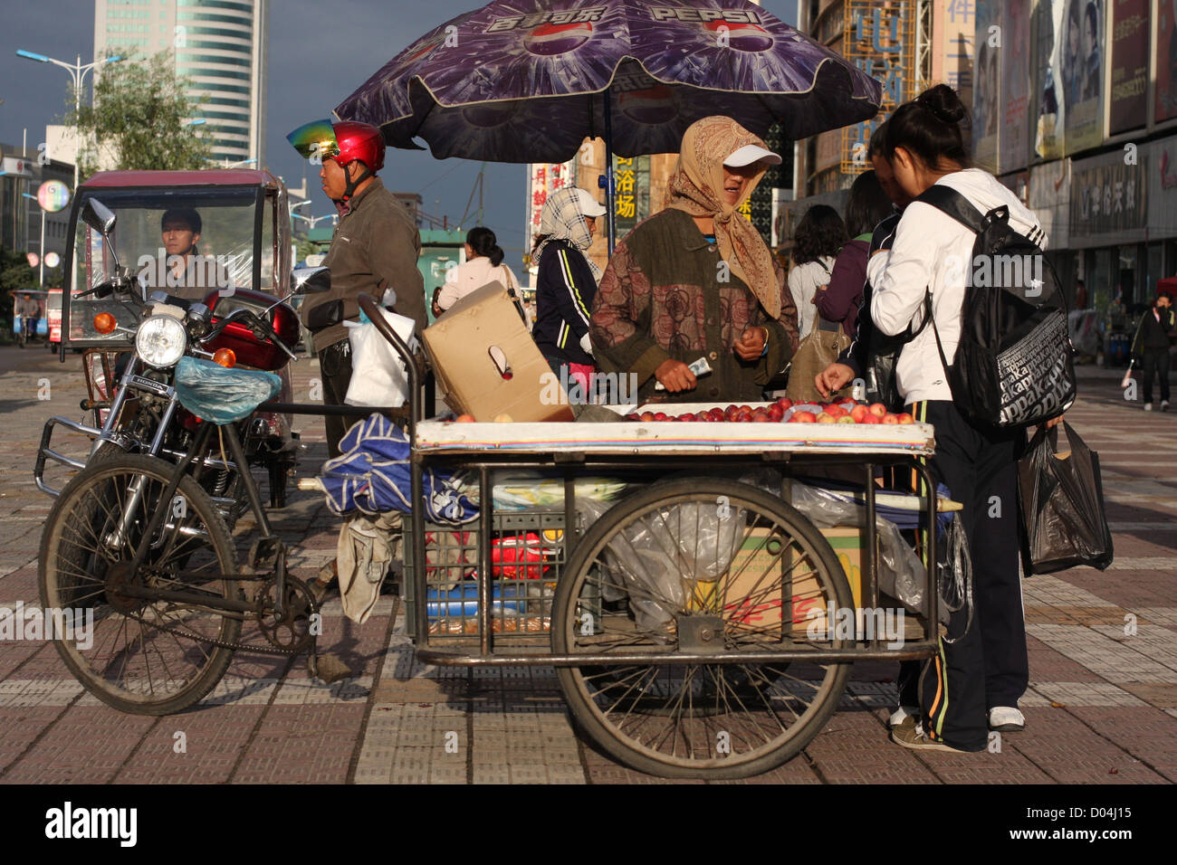 Scène de rue avec apple vendeur, Qiqiha'er, Heilongjiang, Chine Banque D'Images