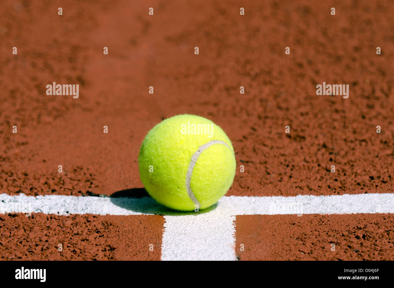 Une balle de tennis sur la ligne blanche Banque D'Images