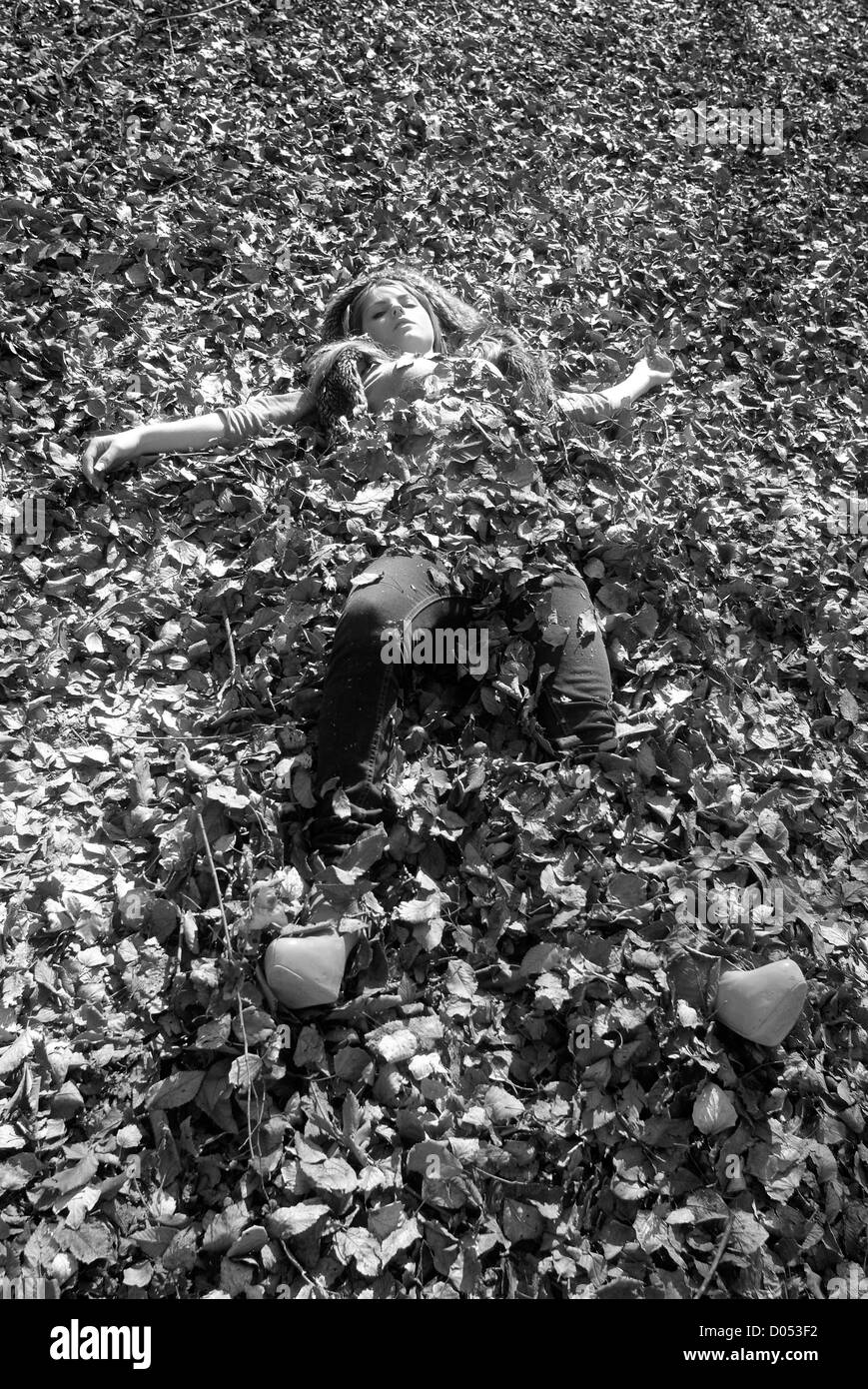 Femme enfouie dans les feuilles de chêne Banque D'Images