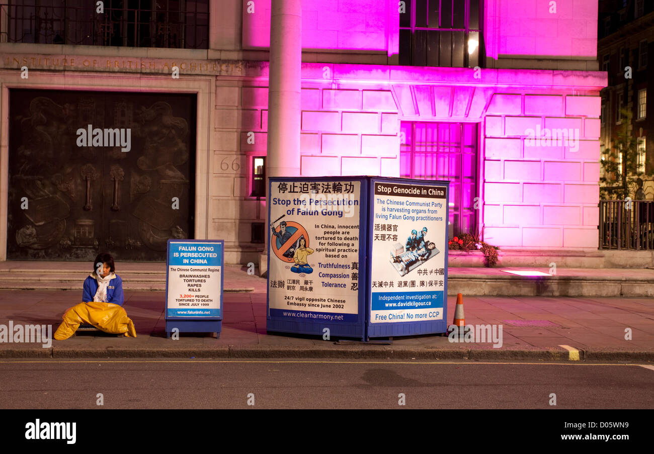 Le Falun Gong manifestant est assis sur le trottoir en face de l'ambassade de Chine à Portland Place, London, England, UK Banque D'Images