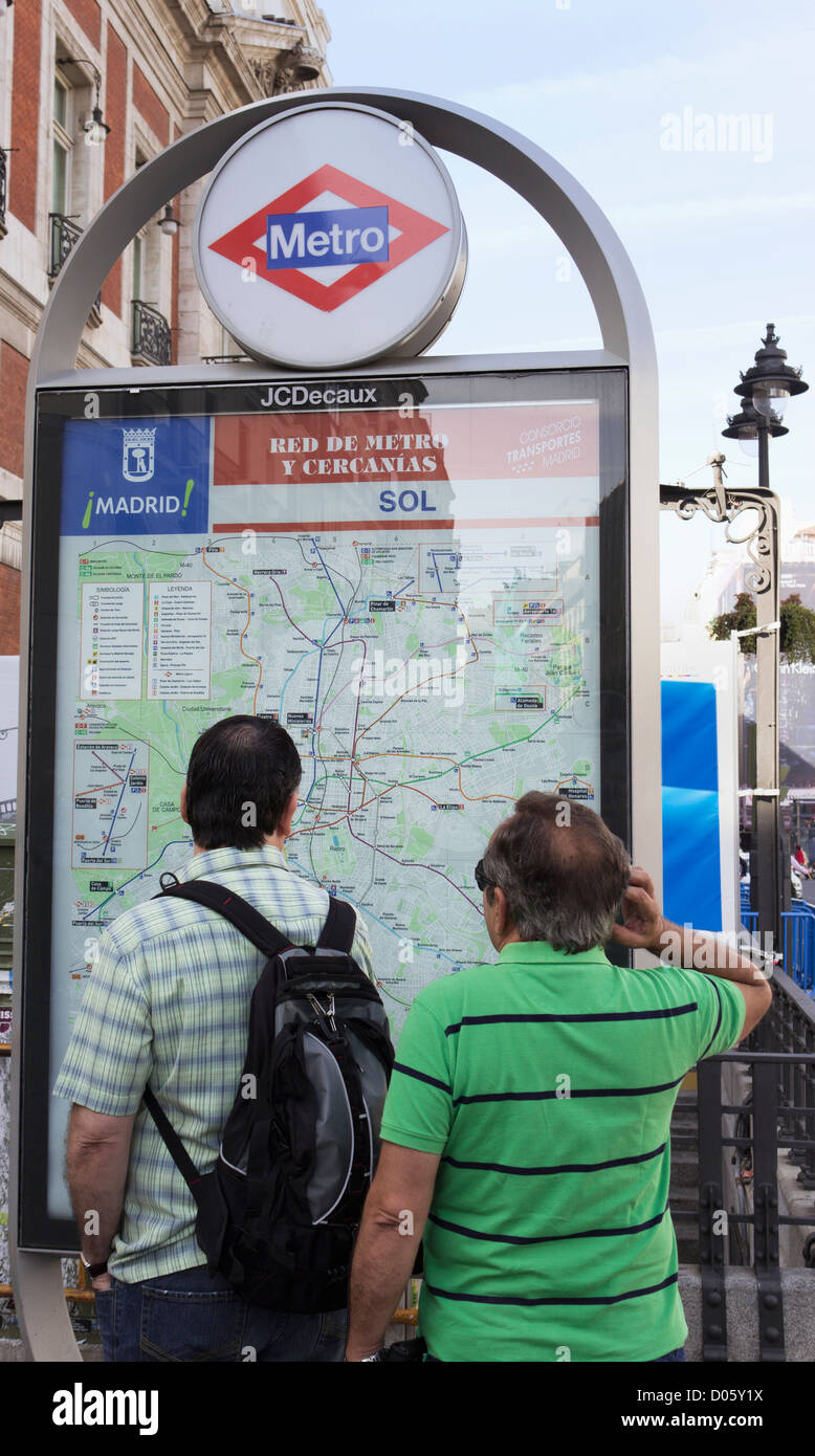 Madrid, Espagne. Les touristes à la recherche d'instructions sur plan du métro. Banque D'Images