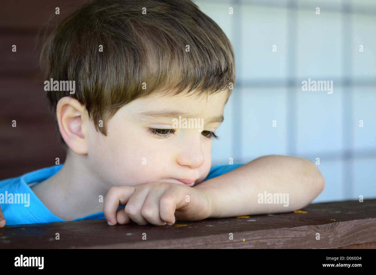 Un enfant mélancolique sur le porche Banque D'Images