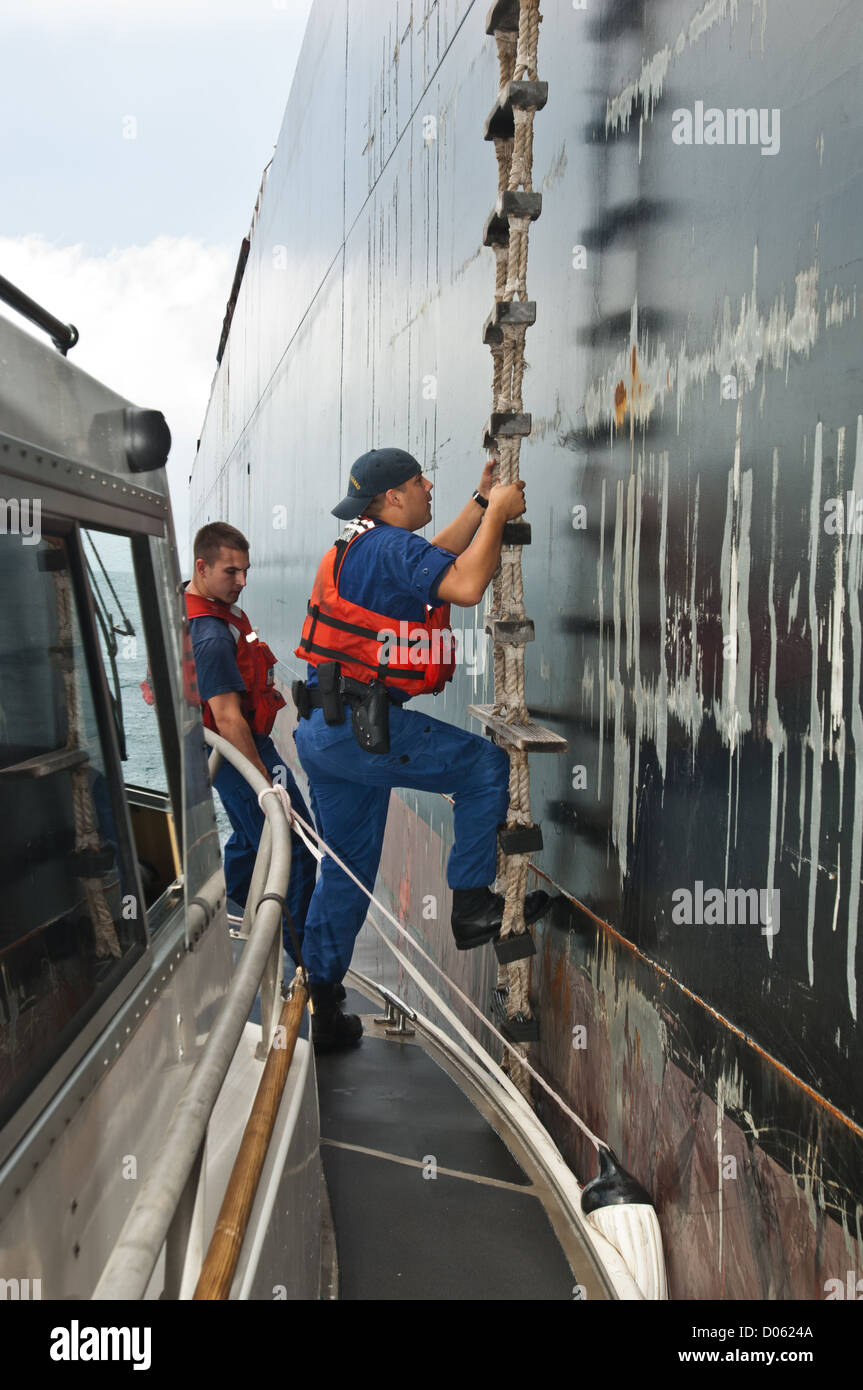 Les agents de la Garde côtière américaine échelle de corde de montée à bord d'un navire-citerne, Port Aransas Texas Banque D'Images