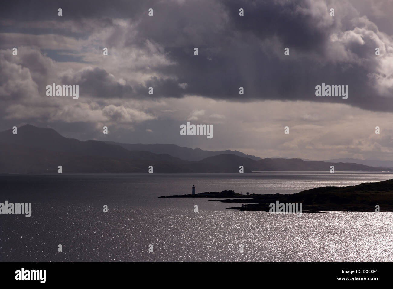 Ciel dramatique et de la lumière du soleil plus de Sound of Sleat avec Isle Ornsay phare dans la distance, Ecosse, Royaume-Uni Banque D'Images