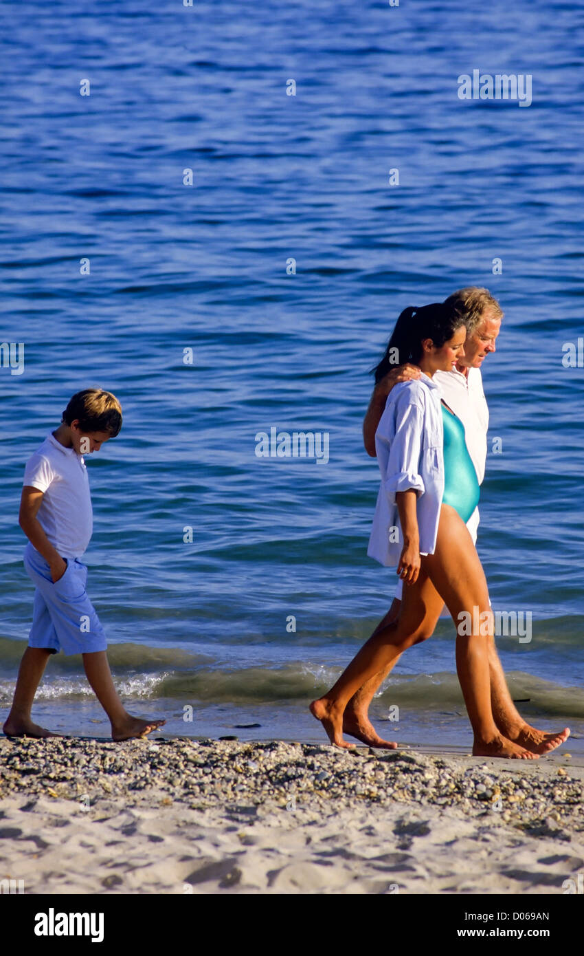 Sulky garçon marchant derrière un couple avec une femme enceinte sur la plage, France, Europe Banque D'Images