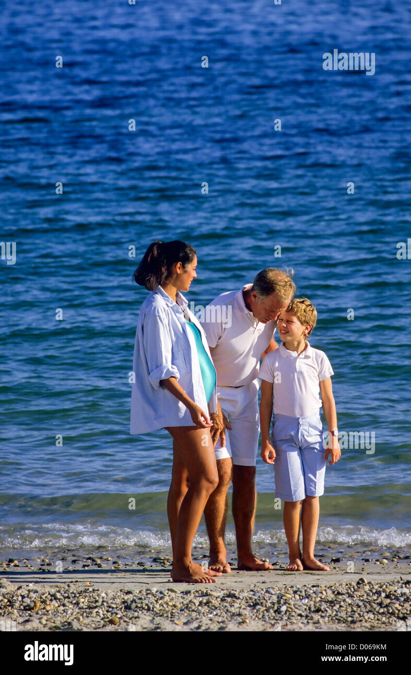 Couple avec femme enceinte et garçon sur la plage, père parlant avec son fils, Banque D'Images