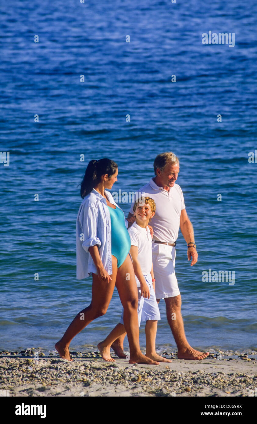 Couple avec femme enceinte et garçon strolling on beach Banque D'Images