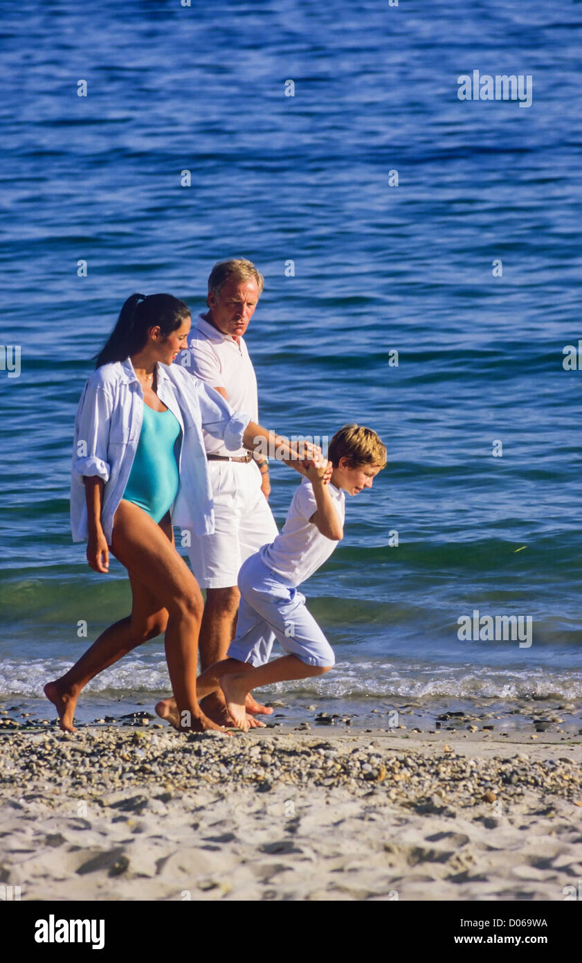 Couple avec femme enceinte et garçon strolling on beach Banque D'Images