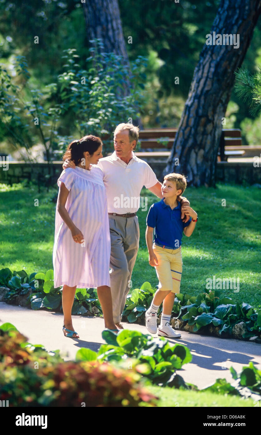 Couple avec femme enceinte et garçon promenade dans park Banque D'Images