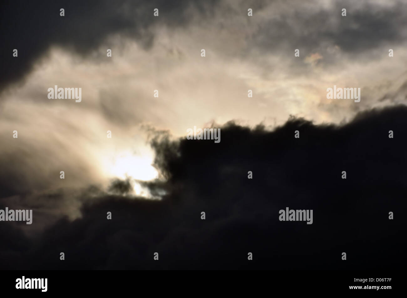 Pâle lumière brillant à travers les nuages noirs. Nuageux ciel d'hiver. Banque D'Images
