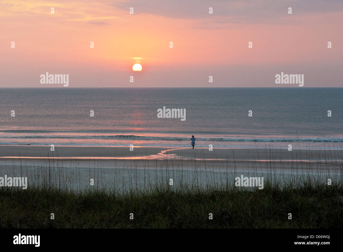 Couple en train de marcher sur la plage de l'océan Atlantique au lever du soleil à Amelia Island, Floride Banque D'Images