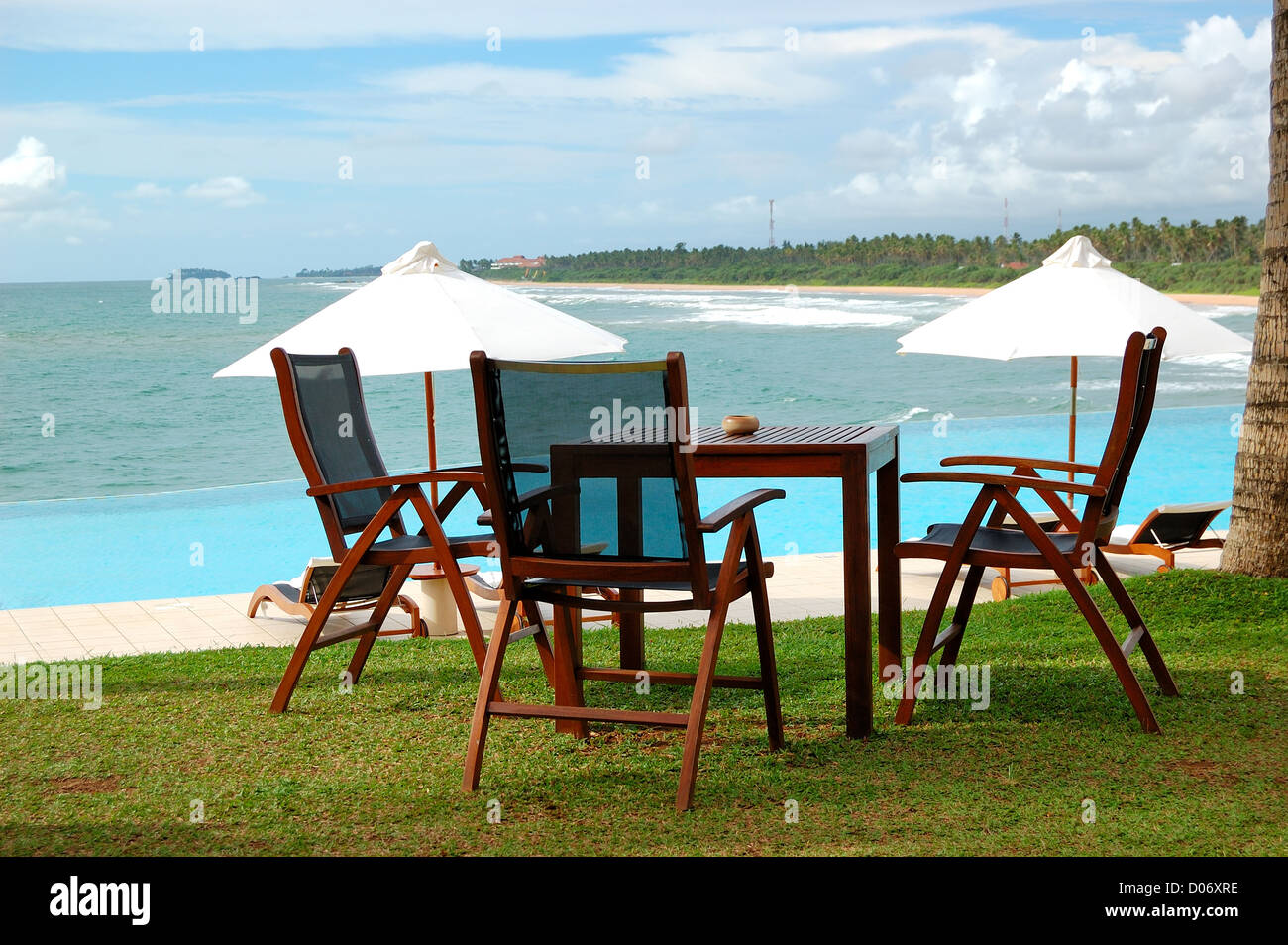 Chaises longues et président du restaurant en plein air à la vue sur la mer piscine, Bentota, Sri Lanka Banque D'Images