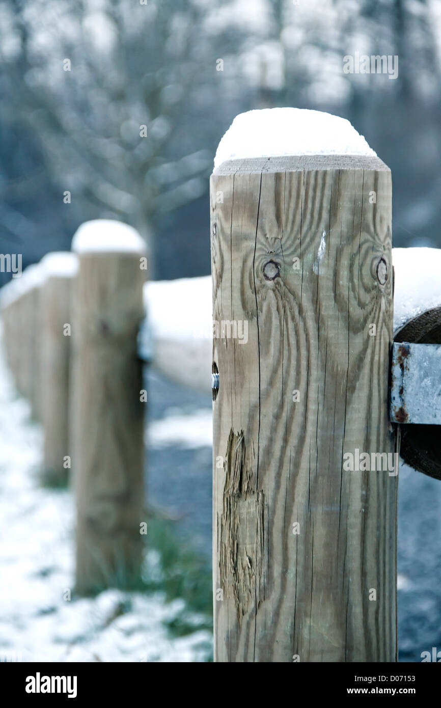 Les poteaux de clôture en bois dans la neige. Banque D'Images